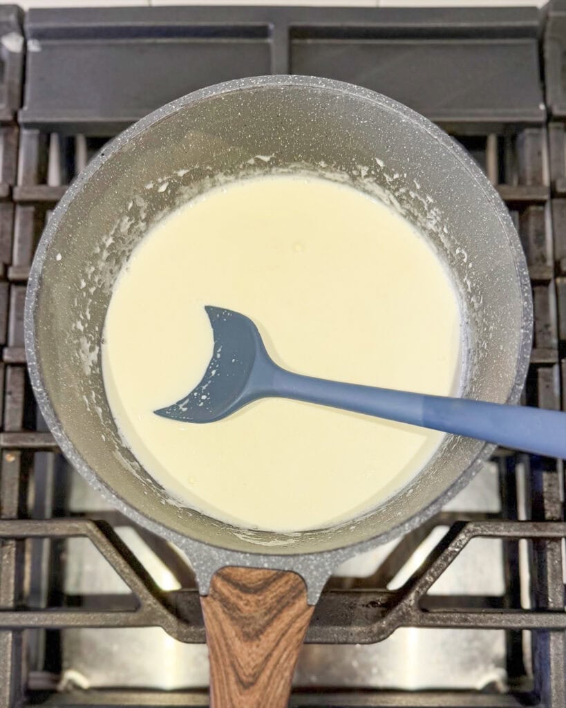 A pot of milk cooking on the stove.