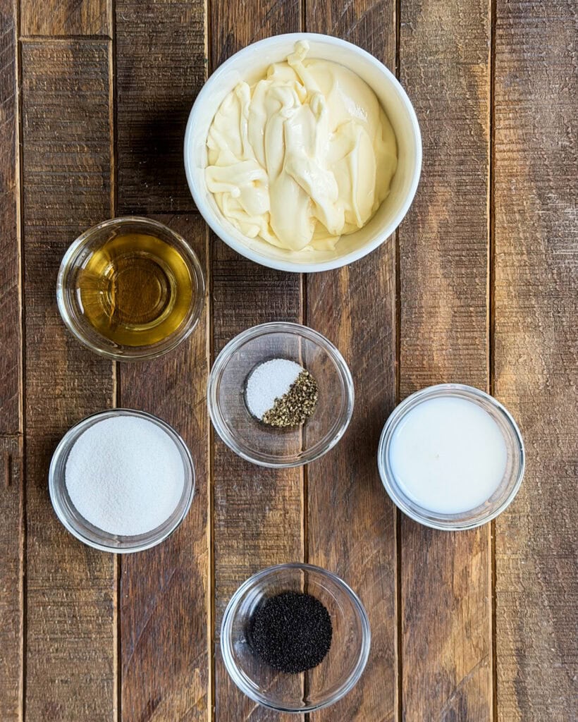 The ingredients needed to make poppy seed dressing in small bowls.