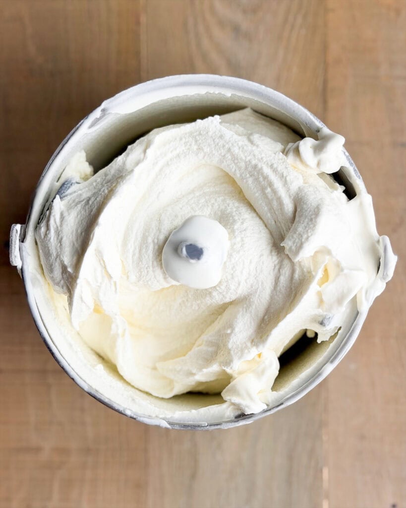 Cheesecake ice cream in an ice cream machine bowl.