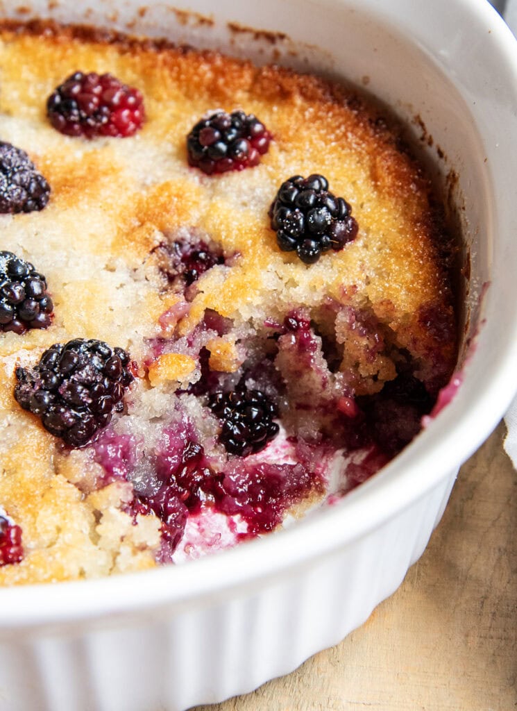 A pan of blackberry cobbler with a scoop removed.