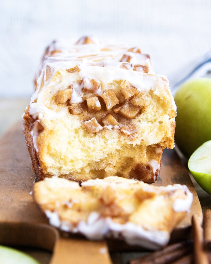 A slice of apple fritter bread on a wooden tray.