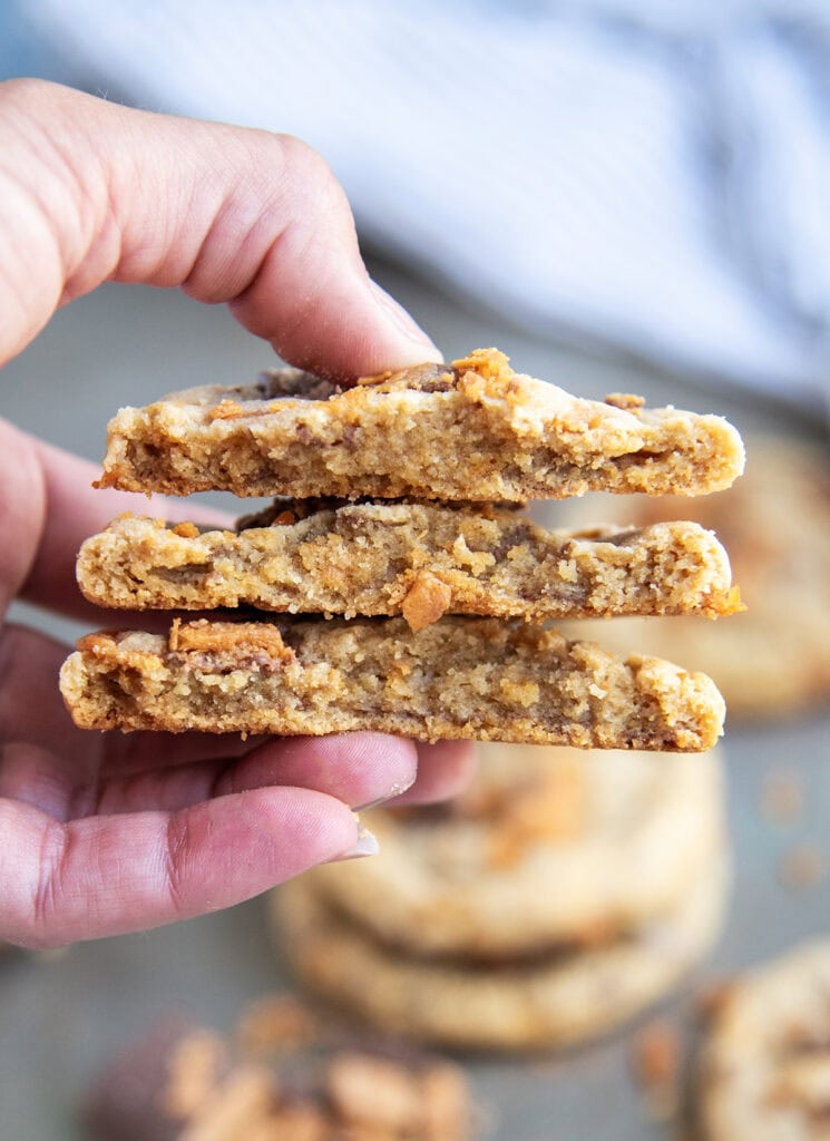 Three butterfinger cookie halves held in a hand showing the centers of the cookies.