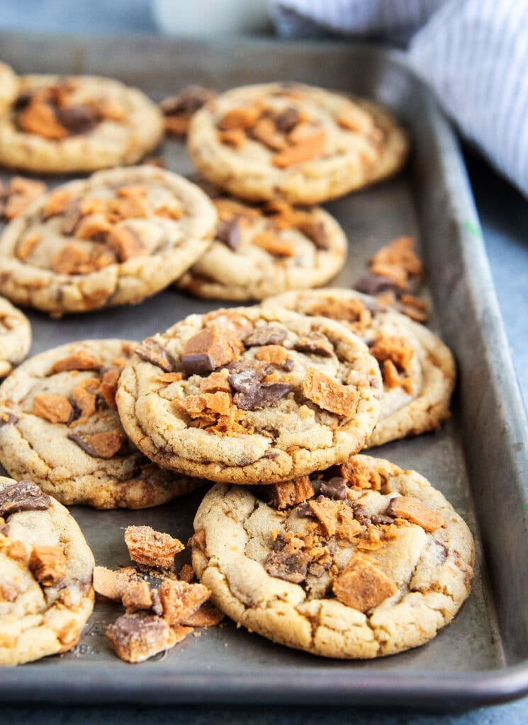 A close up view of peanut butter butterfinger cookies on a cookie sheet. 