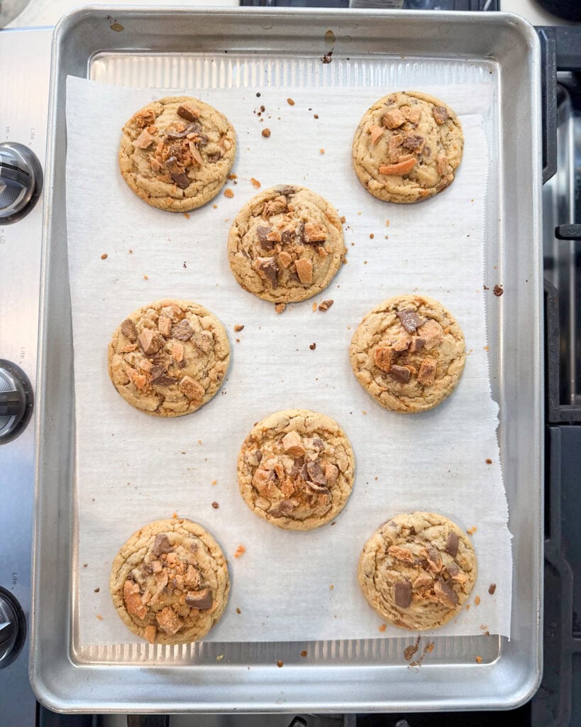 Peanut Butter Butterfinger Cookies on a cookie sheet sitting on the stove top.