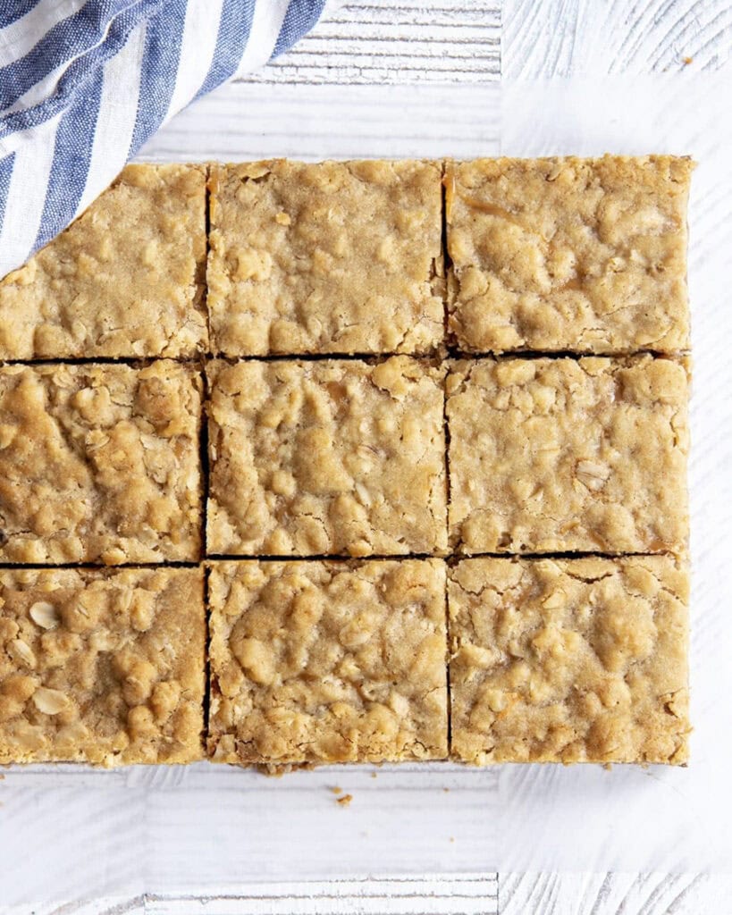 An overhead shot of sliced caramel chocolate oatmeal bars still together in a block.