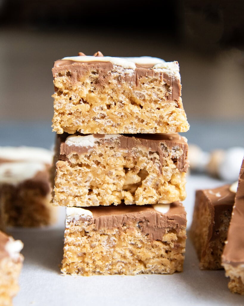 A stack of three scotcheroos topped with chocolate and white chocolate.