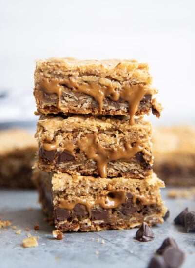 A stack of three oatmeal cookie butter cookie bars with gooey cookie butter coming out of the bars.