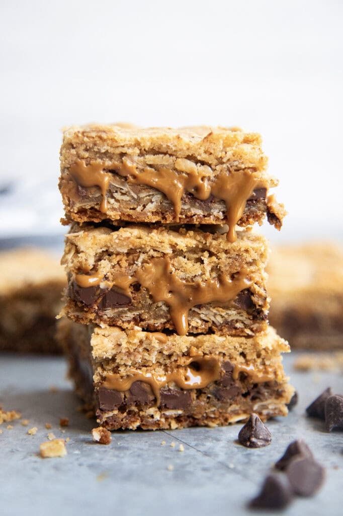 A stack of three oatmeal cookie butter cookie bars with gooey cookie butter coming out of the bars.