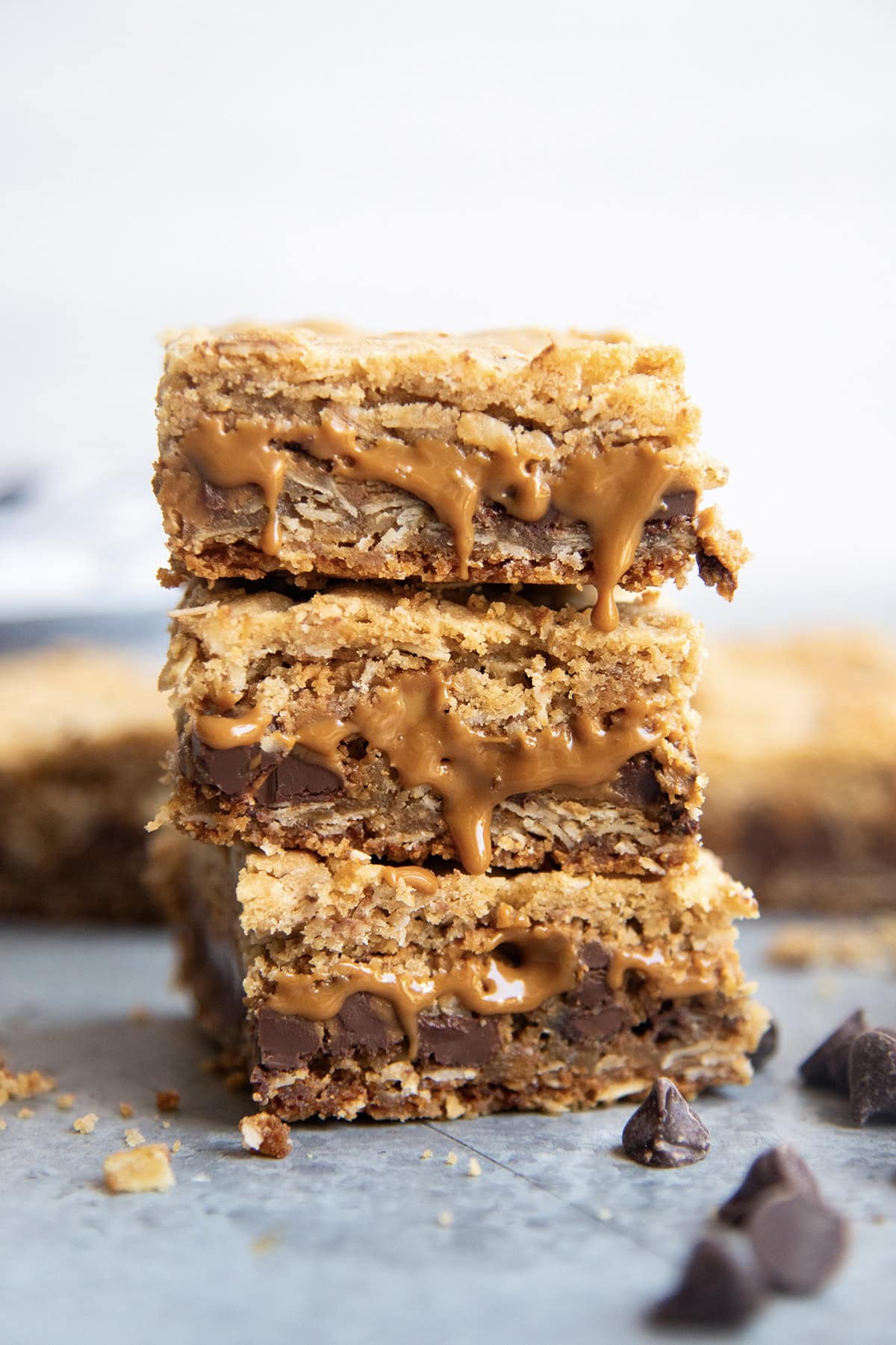 A stack of three oatmeal cookie butter cookie bars with gooey cookie butter coming out of the bars.