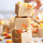 A stack of three pieces of peanut butter fudge with candy corn pieces in it.