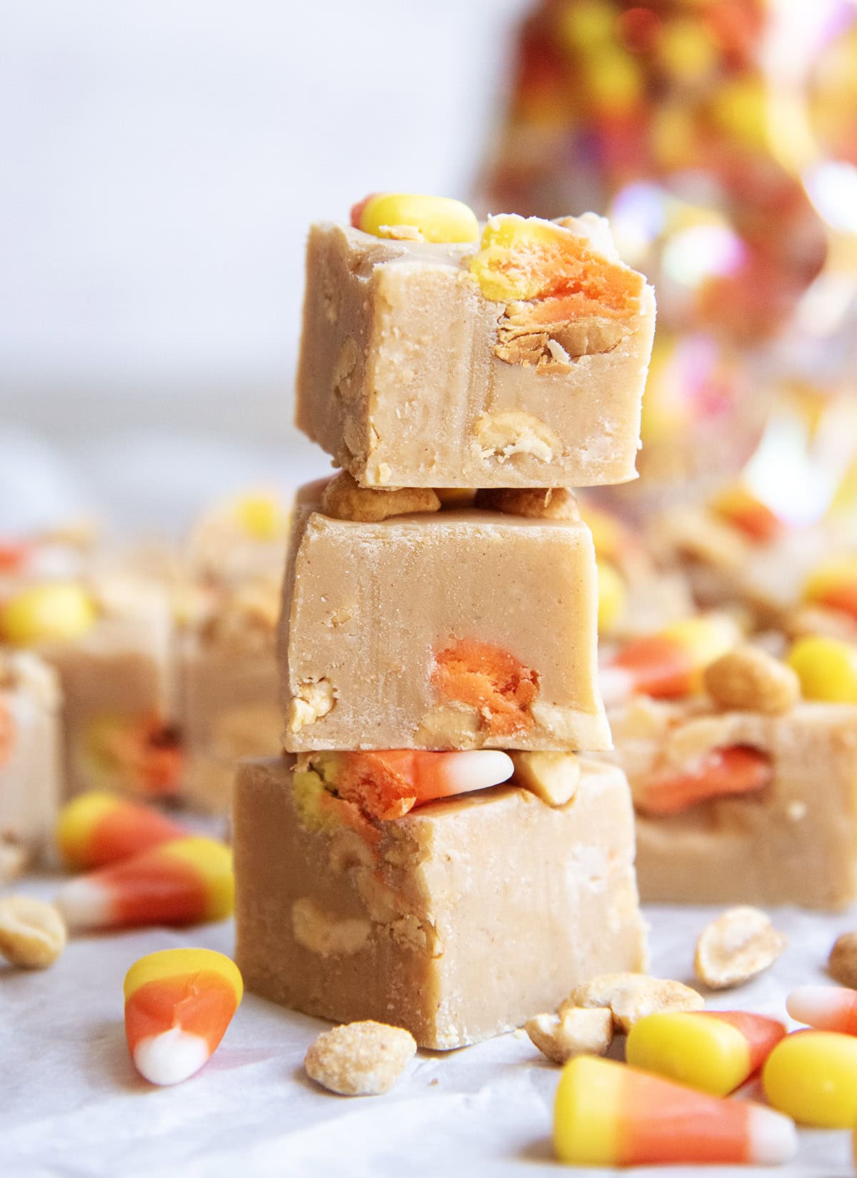 A stack of three pieces of peanut butter fudge with candy corn pieces in it.