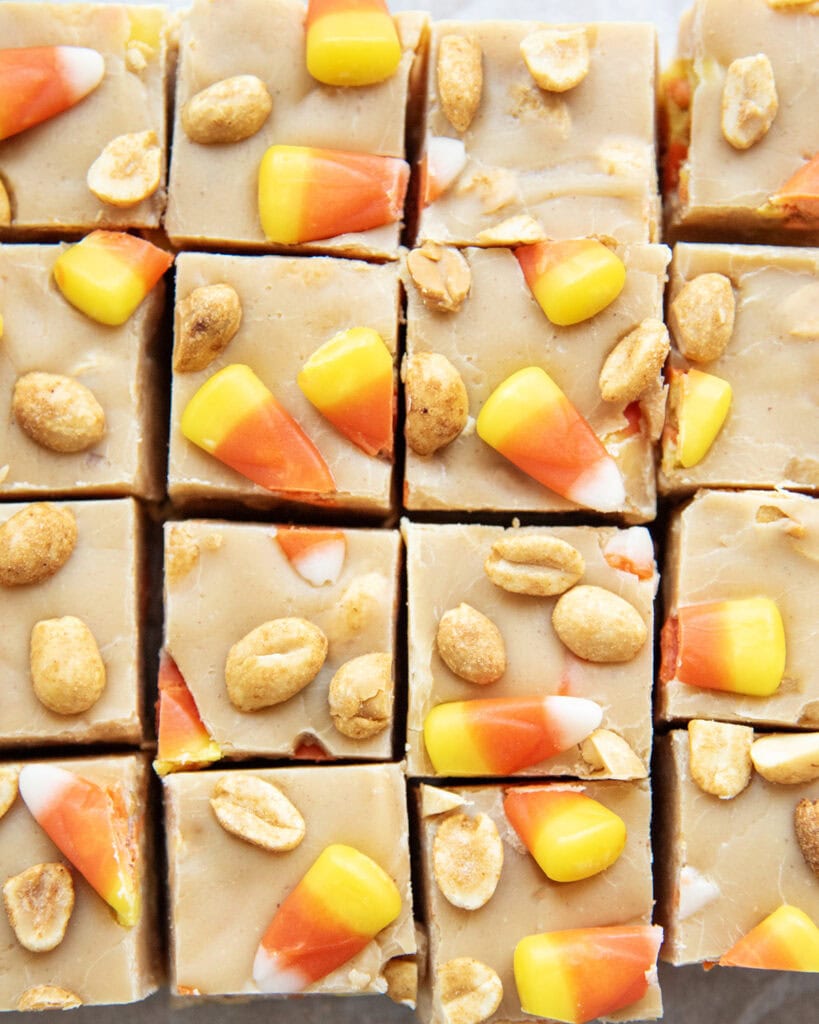 An above view of rows of peanut butter candy corn fudge, with peanuts in them.